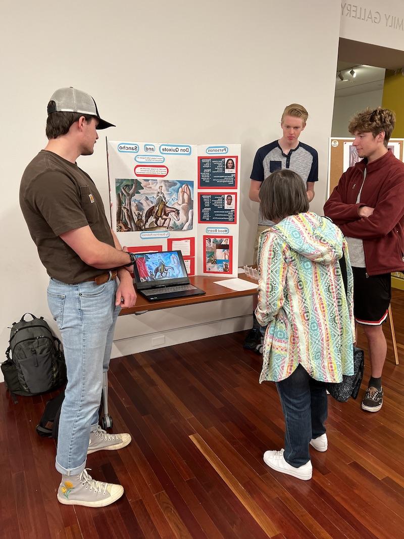 3 students present their findings in a trifold